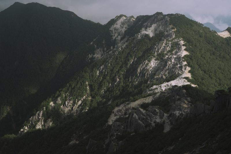日差しが差し込む鳳凰三山の山肌の写真
