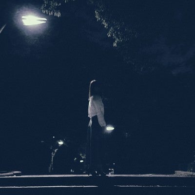 深夜の街灯のあかりと女性の写真