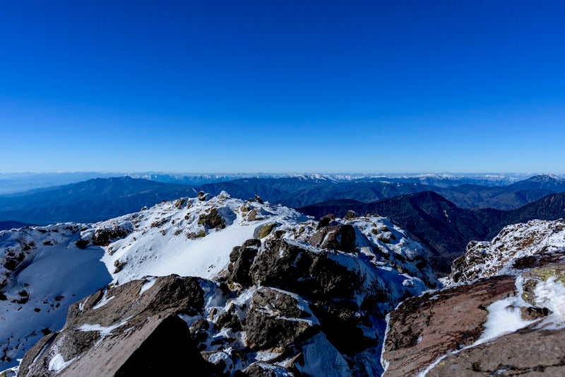 真っ青な空の下の日光白根山山頂、西側方面を望むの写真