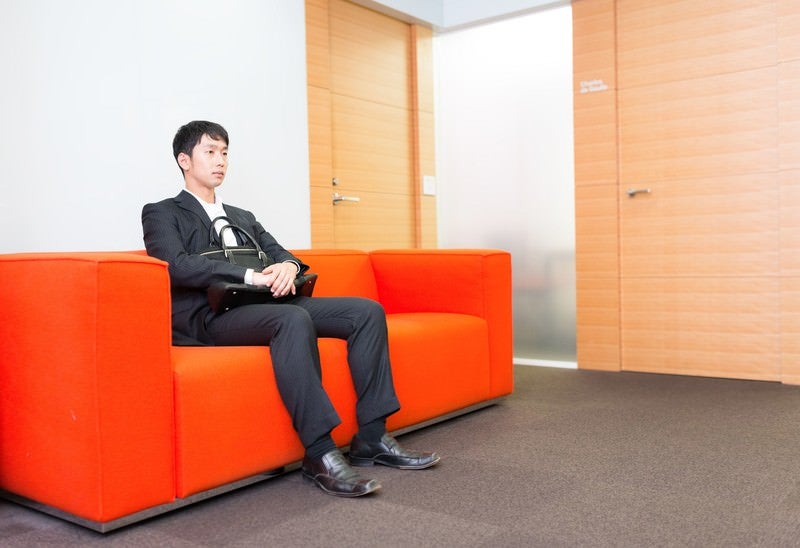 大事な打ち合わせの前に待合室で緊張する新人営業マンの写真
