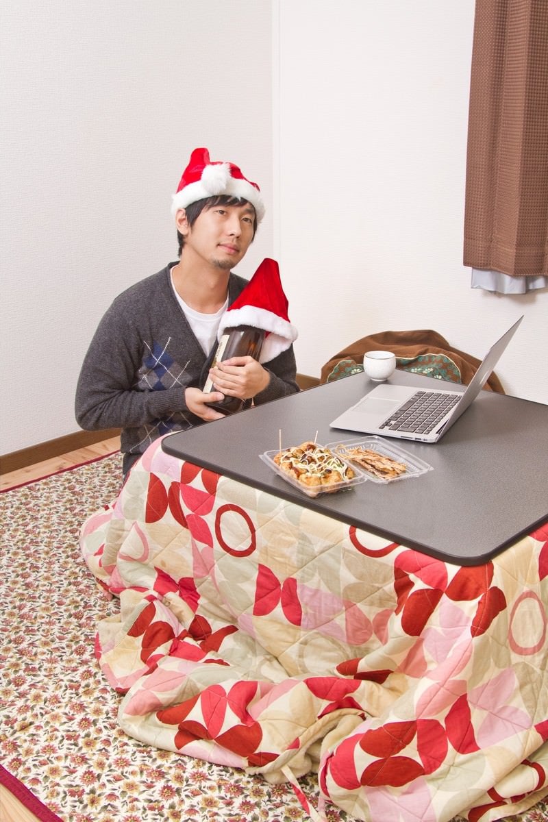 「サンタ帽をかぶり酒瓶と聖なる夜を過ごす切ない表情のクリぼっち」の写真［モデル：大川竜弥］