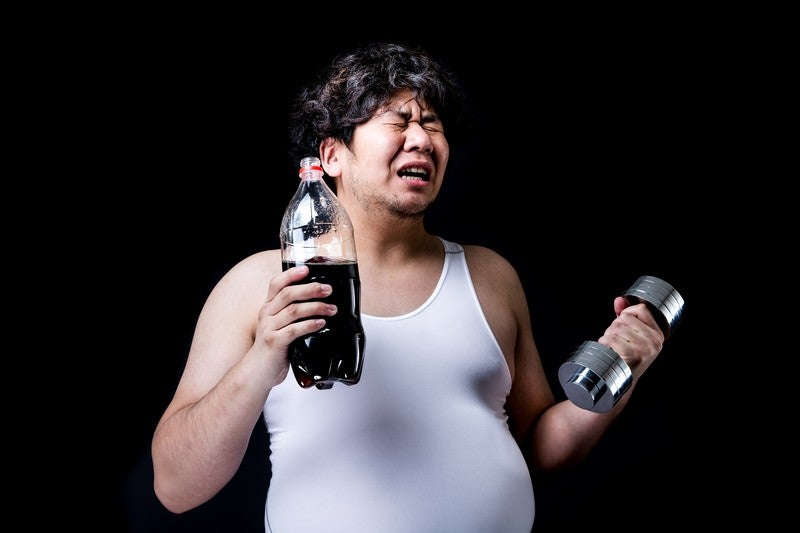 コーラの重さでダンベルの重さを決めるダイエッターの写真