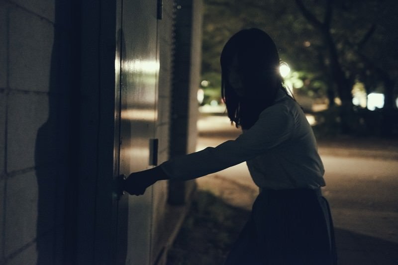 意を決して扉に手をかける女性の写真
