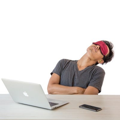 アイマスクをして仮眠を取る男性の写真