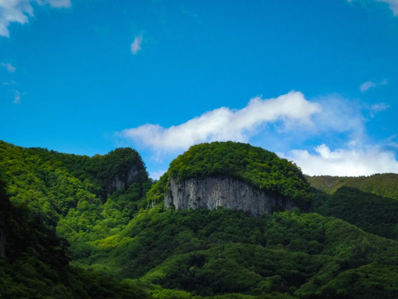 青空と絶壁の丸岩の写真
