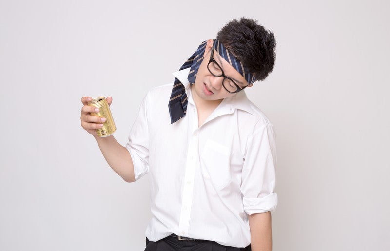 缶ビールを持った酔っぱらった会社員の写真