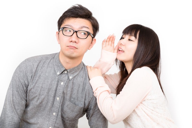 いいこと教えてあげるから耳を貸してと内緒話をする恋人の写真