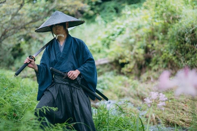 抜いた刀を肩にかける網代笠の武士の写真