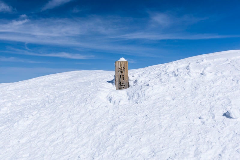 雪に埋まった谷川岳山頂標の写真