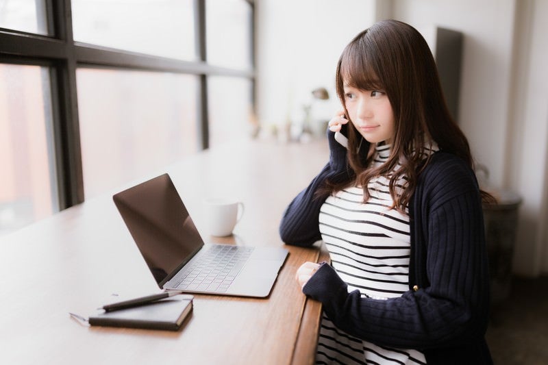 クライアントへ確認の電話を入れるIT女子の写真