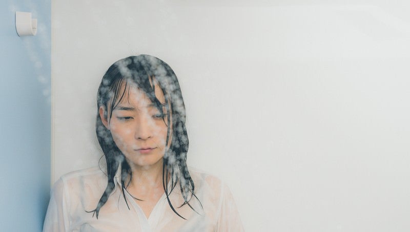 シャワーで涙を流す失恋女子の写真