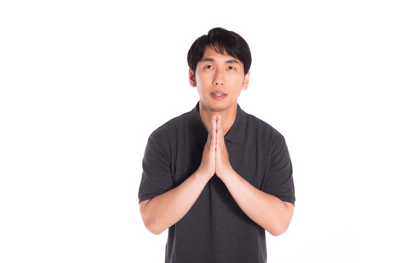 手を合わせて感謝する男性の写真