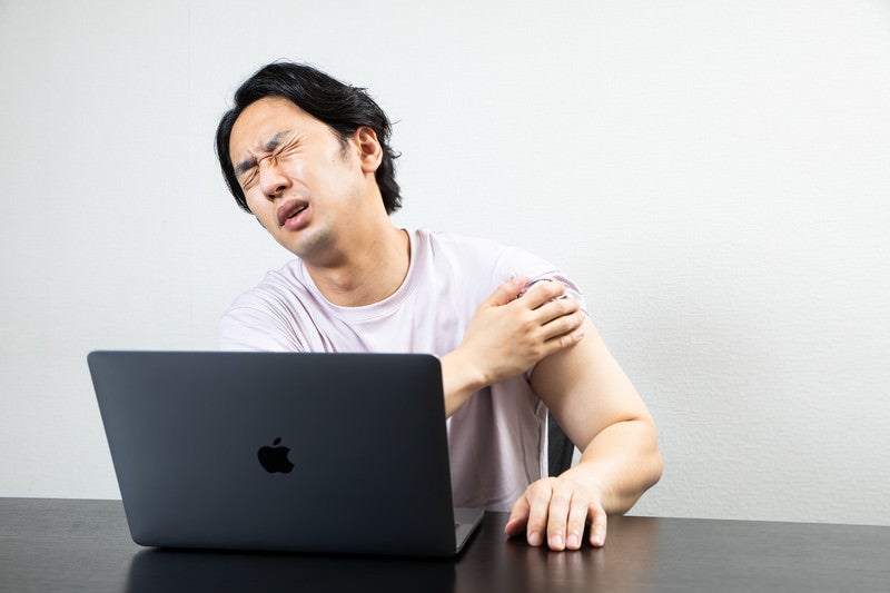 ワクチン接種の副反応が痛む男性の写真