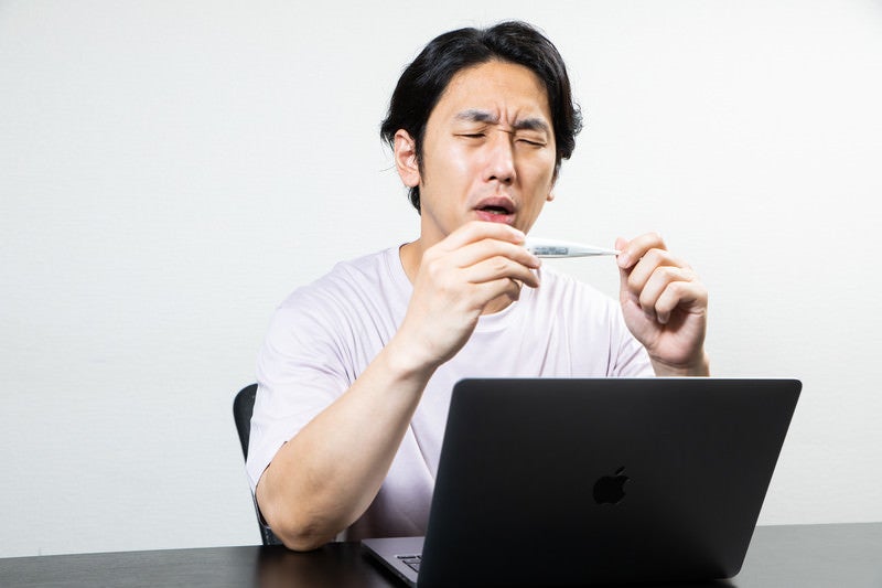 体調が悪いので体温を測ったら高熱だった時の男性の写真