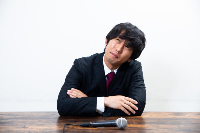 困った表情で考え込む男性社員の写真