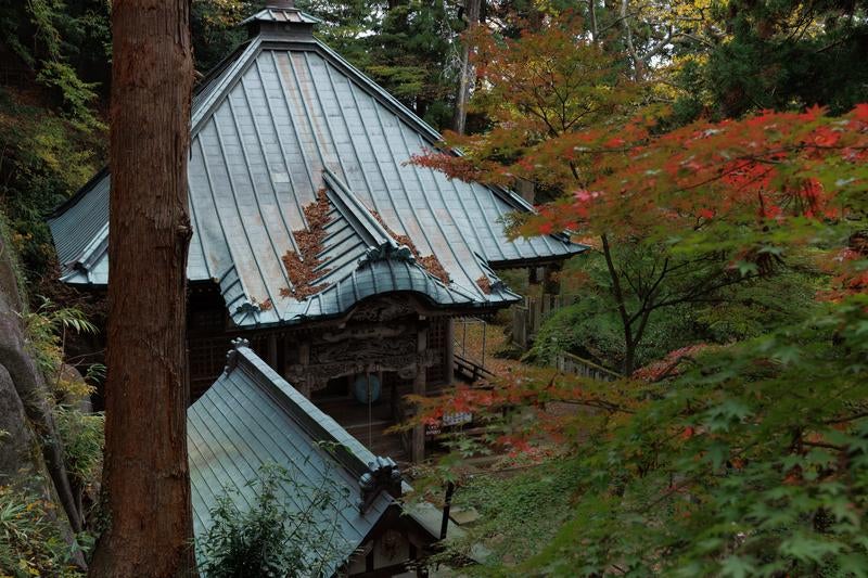 岩角寺の静かな毘沙門堂と境内の神聖な調和の写真