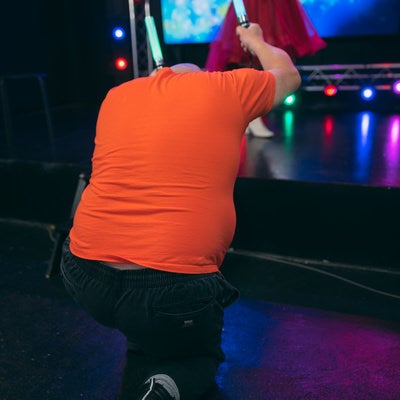 ステージ上のアイドルにペンライトを向けるの写真