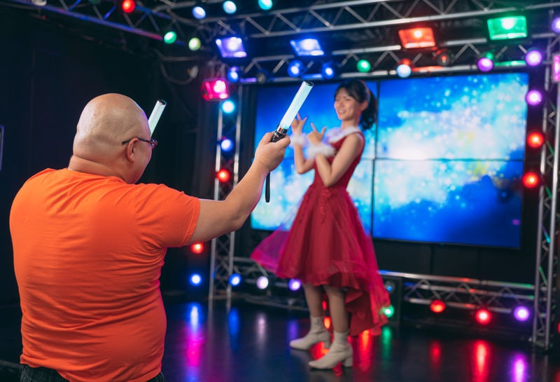 推しのアイドルイベントでペンライトを振る男性の写真