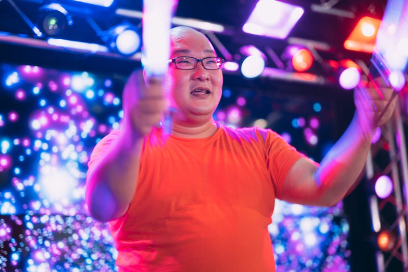 ペンライトを使った芸を披露する男性の写真