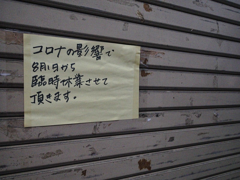 シャッターに張られたコロナの影響で臨時休業のビラの写真