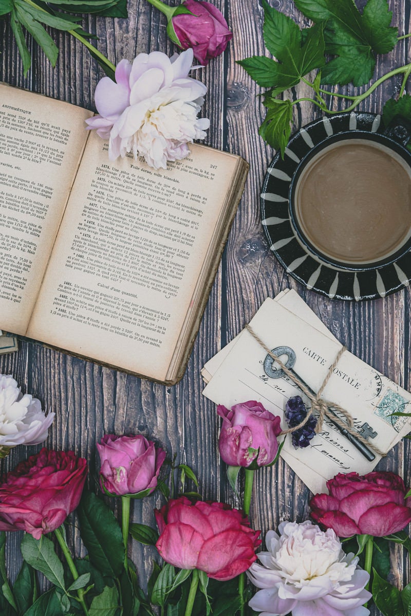 テーブル上におかれた薔薇や洋書類の写真