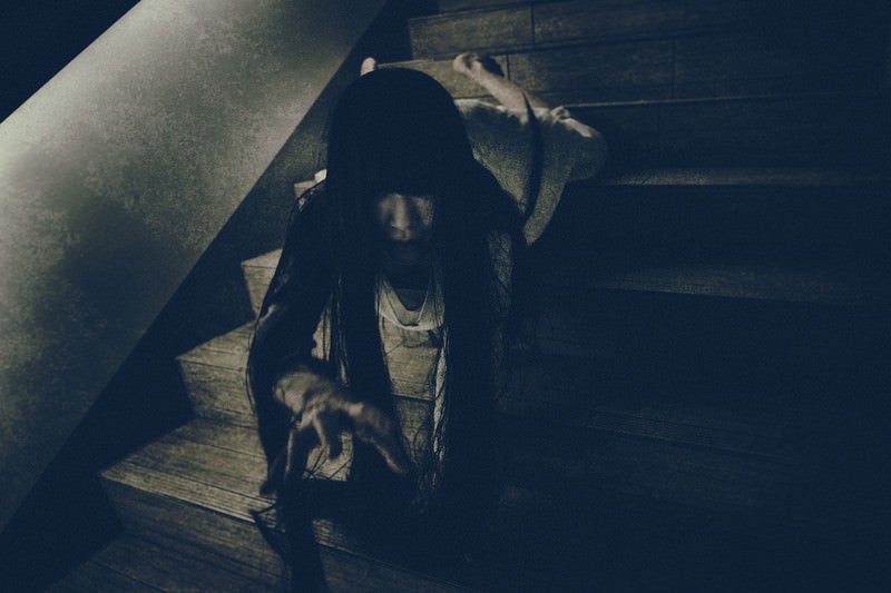 階段を這い降りながらこちらに手を伸ばす女性の写真
