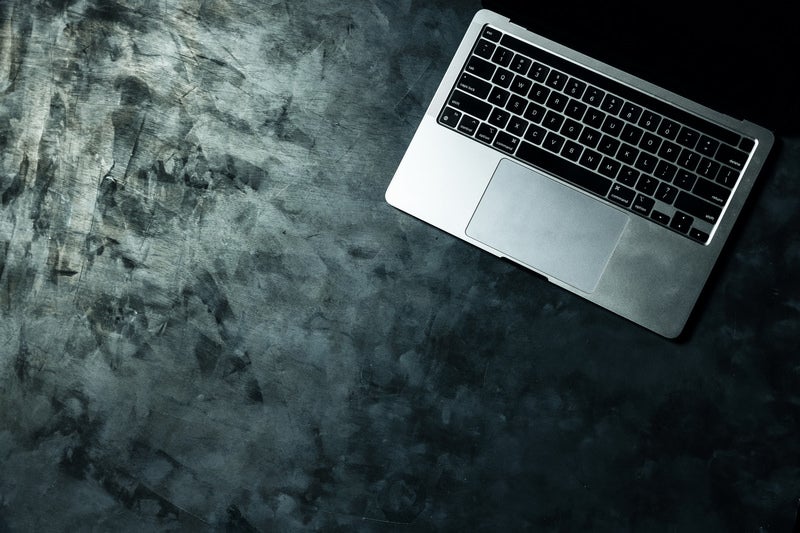 粗いテーブル上のMacBookの写真