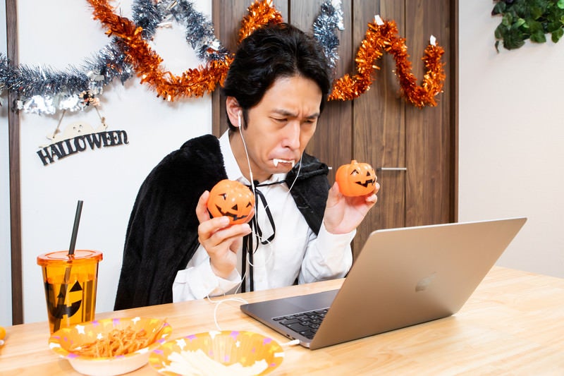 ハロウィンのオンライン記念撮影でポーズを決める男性の写真