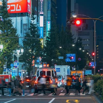 新宿区役所前の横断歩道を渡る人（夜間）の写真