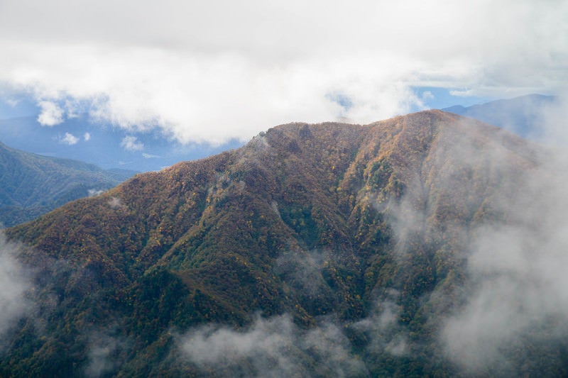 雲がかかる谷川連峰の秋の写真