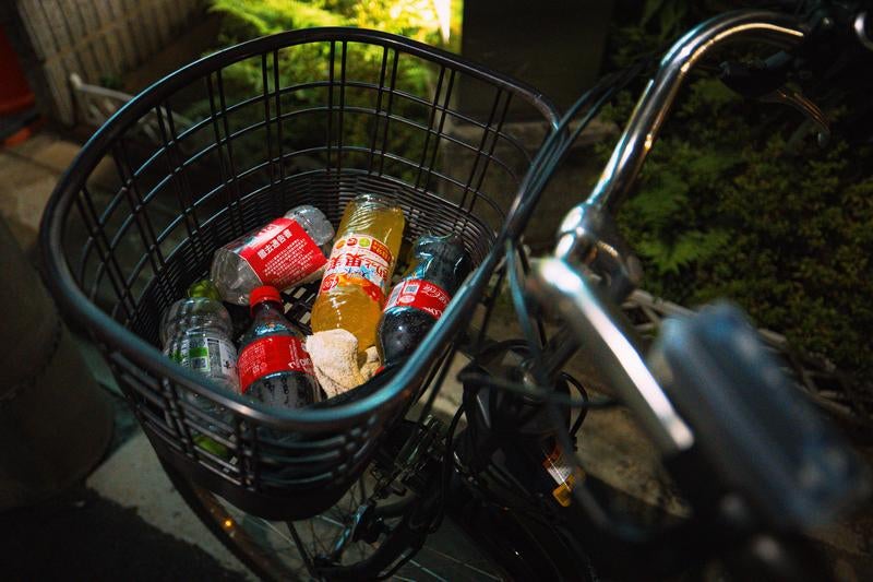 駐輪している自転車のかごにペットボトルのポイ捨ての写真