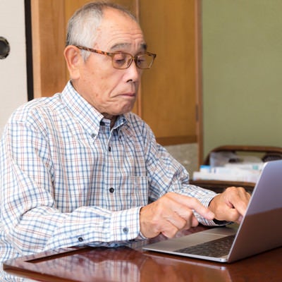 MacBook でブログを書くお爺さんの様子の写真