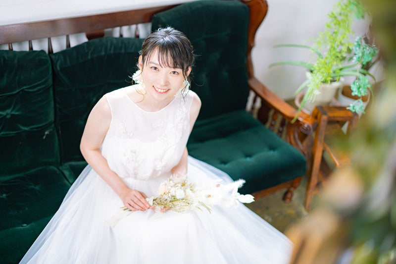 白いウェディングドレスを着た幸せな表情の女性の写真