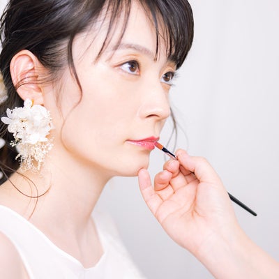 唇のメイク中の花嫁の写真