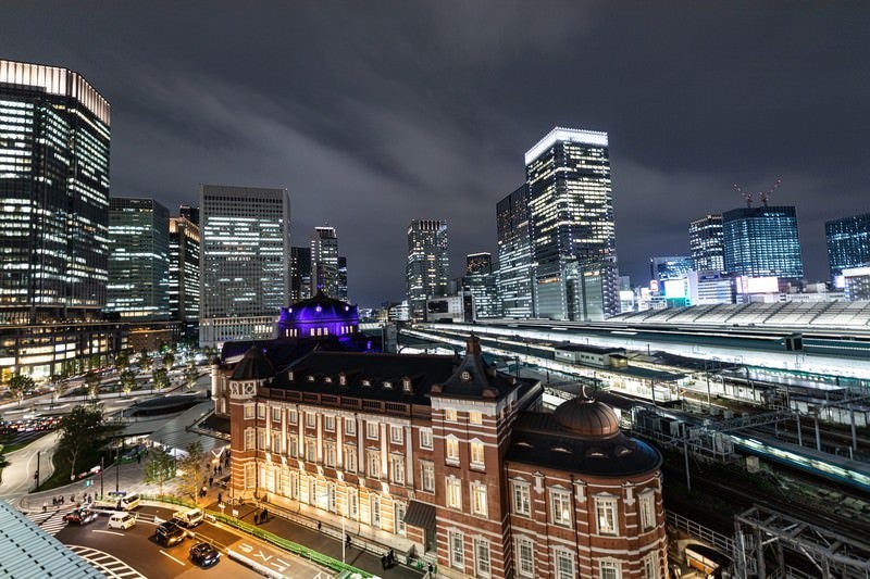 夜の東京駅越しに見る丸の内ビル群の夜景の写真