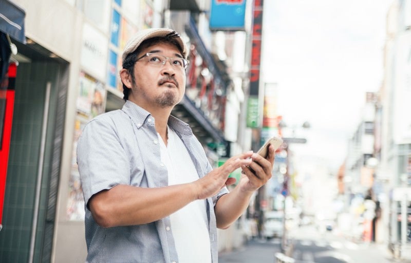 お店の場所がなかなか見つからない男性（迷子クラスタ）の写真