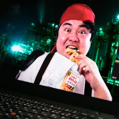 ポテチ食べながらビデオ通話する男性の写真